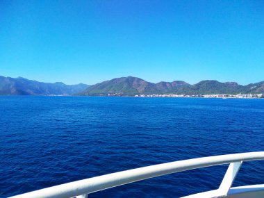 Uzak sahil manzarası. Derin mavi okyanusla yaz turizmi. Gemiden görüntü. Tekne gezisi