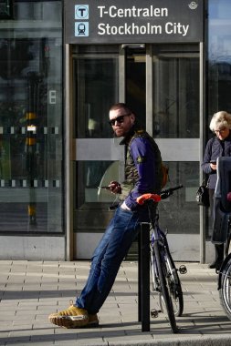 Stockholm, İsveç Genç bir adam şehir merkezinde T-Centralen de bisikletine yaslanır.