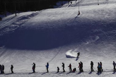 Orsa, Dalarna eyaleti, İsveç Downhill kayakçıları güneşli bir günde Orsa kayak merkezinde bir telesiyej de sırada bekliyor.