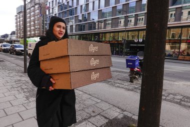Stockholm, İsveç Vasagatan üzerinde bir kadın hamur işleri kutuları taşıyan.