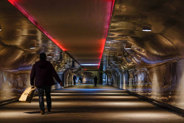 Стокгольм, Швеция Люди в пешеходном туннеле, ведущем к поезду, в Якобсе, жилом пригороде к северу от города
.