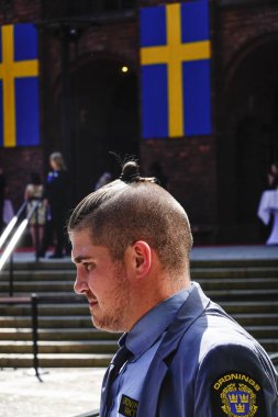 Stockholm, Sweden A security guard with a man bun at the City Hall. clipart