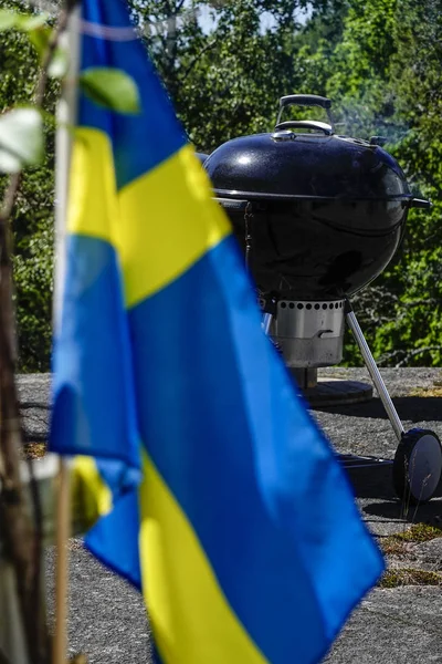 Stockholm, Sweden A grill and a Swedish flag is a symbol of Swedish midsummer.