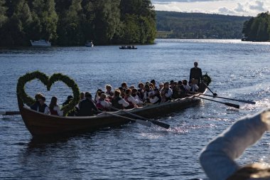 Leksand, Sweden The Swedish midsummer celebration, the largest such celebration in Sweden, where row boats with live music come with singing and instrument playing passengers to land to start the festivities. clipart