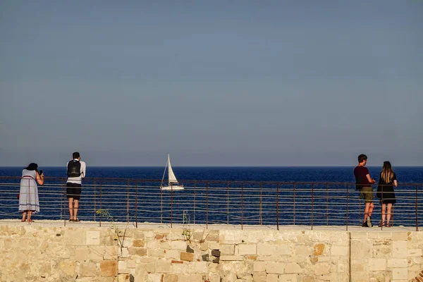 シラキュース シチリア イタリアのカップルは オルテギア島 またはオルティギア島のシラクーサの町で古いフォートやカステッロマニアの城壁に海の景色とヨットを楽しんでいます — ストック写真