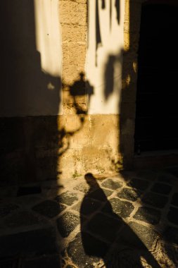 Syracuse, Sicilya, İtalya Yayalar Ortygia veya Ortigia adasında geç öğleden sonra bir sokak lambası gölgesinde yürümek.