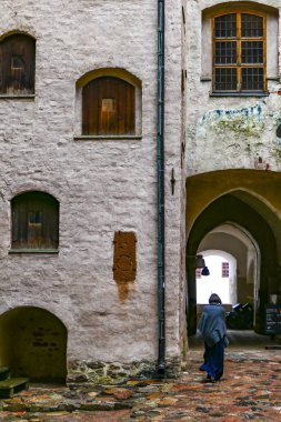 Turku, Finlandiya 'da 13. yüzyıl Turku Kalesi' nin avlusunda uzun elbiseli bir kadın yürüyor..