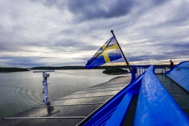Turku, Finlandiya. Bir İsveç bayrağı feribotun kıç tarafında dalgalanır..