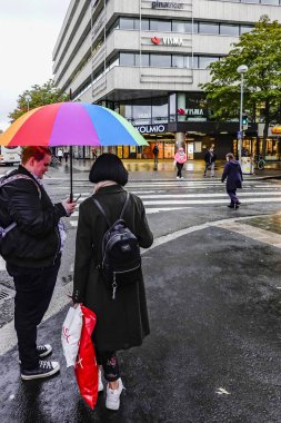 Turku, Finlandiya, renkli şemsiyeli bir çift sokak köşesinde duruyor..
