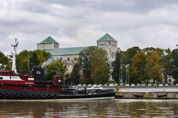 Turku, Finland The Aura river, a tugboat and the Turku Castle.