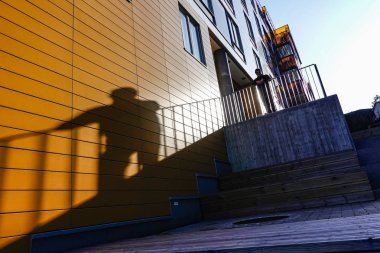 Stockholm, İsveç Liljeholmskajen 'de bir adam ve gölgesi.