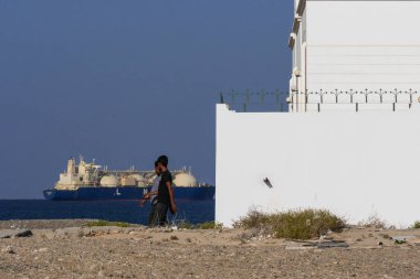 Sur, Umman Sahil Kasabası Muscat 'in 250 kilometre doğusunda. Günlük hayat ve manzaralar. Köy. Denizdeki gemi terminale gelmek için bekliyor..