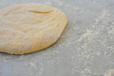 Pizza hamuru tezgahın üstünde duruyor.