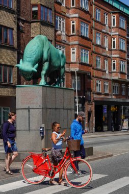 Aalborg, Danimarka Bisikletli bir kadın Cimbrian Boğası 'nın yanından geçiyor, 1937 yılında Anders Bundgaard' ın Orta Aalborg 'da bulunan bronz bir heykeli..