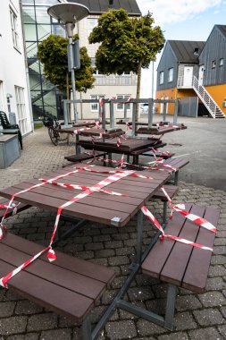 Aarhus, Denmark Picnic tables in old town cordoned off for Coronavirus. clipart