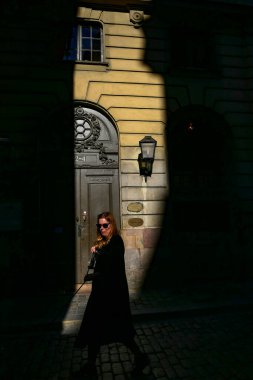 Stockholm, İsveç 'te bir yaya, eski şehrin erken saatlerinde Kallargrand' da bir kapının önünde yürür..