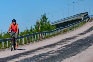 Haparanda, İsveç Seskaro Köprüsü 'nü bir bisikletçi geçiyor.