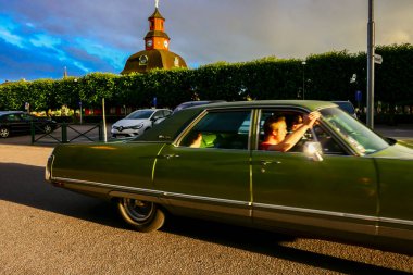 Lidkoping, İsveç batan güneşte Kallaregatan 'a doğru giden klasik bir Amerikan arabası..