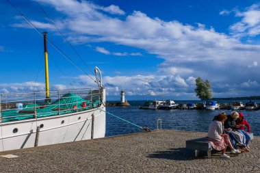 Hjo, İsveçli insanlar rıhtımda oturuyorlar Vattern Gölü 'nün kıyısında