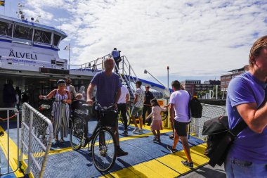 Göteborg, İsveçli yayalar ve bisikletçiler Gota Alv nehri üzerindeki feribottan iniyorlar..