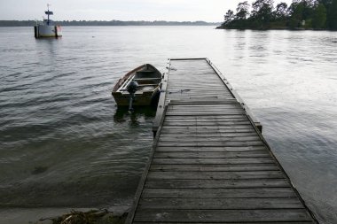 Sater, İsveç Yağmurda Braviken körfezinde küçük bir rıhtım ve bir kayık.