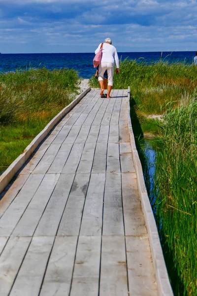 スウェーデンのファルステルボ女性がフロンメン自然保護区の海岸沿いのボードウォークを歩く — ストック写真