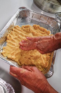 Bir kadın hamur işiyle kiş yapar.