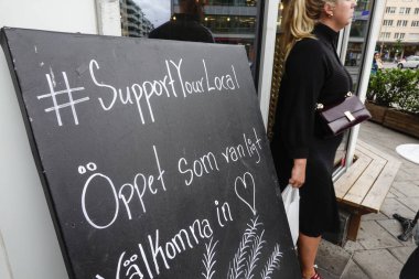 Stockholm, İsveç. İsveç 'te bir kafede yerel hashtag' inizi destekleyin, her zamanki gibi açın, hoş geldiniz, ve bir kişi geçiyor..