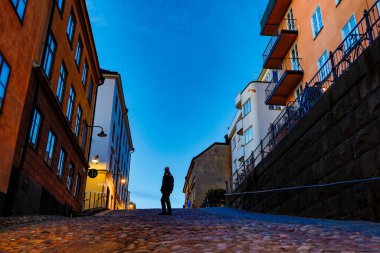 Stockholm, İsveç Sabahın erken saatlerinde tarihi Bellmansgatan 'da yürüyen bir adam.