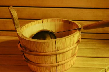 Saunanın içinde tahta bir su kovası.