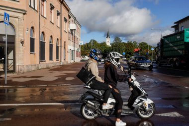 Sunne, İsveçli gençler şehir merkezinde motosiklete biniyor.