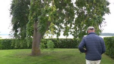 Stockholm, İsveç. Malaren Gölü kıyısında bir adam halka açık bir parkta yürüyor.. 