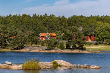 Stendorren, İsveç STendorren Doğa Koruma Alanında kırmızı bir ev ve ahır manzarası.