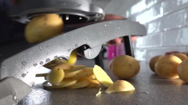 Stockholm, İsveç Bir aşçı ev mutfağında bir mandolin dilimleme makinesi kullanır Patatesleri dilimlemek için. 