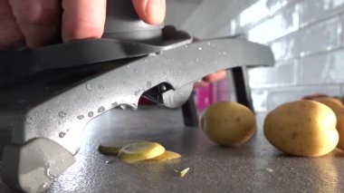 Stockholm, İsveç Bir aşçı ev mutfağında bir mandolin dilimleme makinesi kullanır Patatesleri dilimlemek için. 