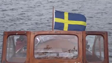 Stockholm, İsveç Klasik ahşap bir teknenin üzerinde bir İsveç bayrağı dalgalanır. 