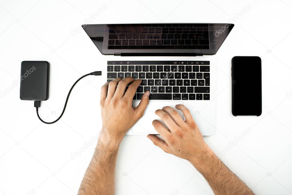 Businessman working with his laptop computer and his smartphone on a white table