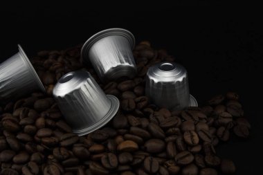 Espresso Kahve kapsüller veya kahve çekirdekleri üzerinde kahve kapsülü, siyah arka plan.