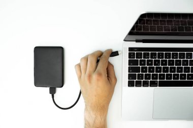 İşadamı beyaz bir masada onun laptop harici sabit disk bağlı.