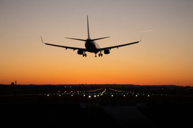 Ticari yolcu uçağı gün batımı sırasında Havaalanı pistinde iniş