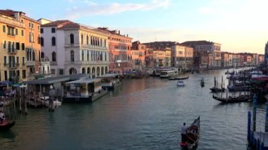 Venedik, İtalya-27 Temmuz 2018: 4K. Büyük Kanal Venedik 'te gün batımı, gondollar, botlar ve buharlı kanallar. Rialto köprüsünden görüntü.