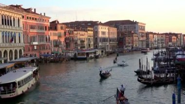 Venedik, İtalya-27 Temmuz 2018: 4K. Büyük Kanal Venedik 'te gün batımı, gondollar, botlar ve buharlı kanallar. Rialto köprüsünden görüntü.