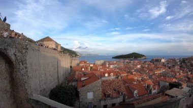 Dubrovnik, Hırvatistan-23 Temmuz 2018: 4K. Çeviriyorum. Hırvatistan 'ın Dubrovnik Eski Kentini çevreleyen duvarda yürüyen turistler görülüyor. Lokrum Adası