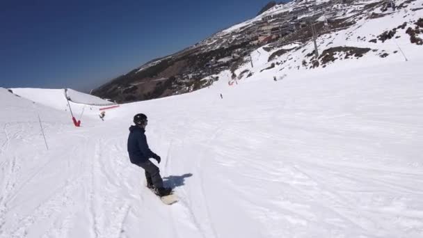 スキーマンはスノーボードで雪の斜面を下り坂している シエラネバダ スペイン エイドリアンの晴れた日 — ストック動画