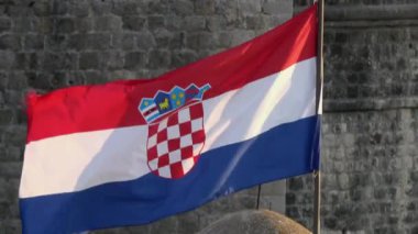 4 bin. Hırvatistan bayrağı Dubrovnik 'in duvarlarında rüzgarda sallanıyor. Hava kararıyor. Ortasında Hırvatistan 'ın arması yer alıyor