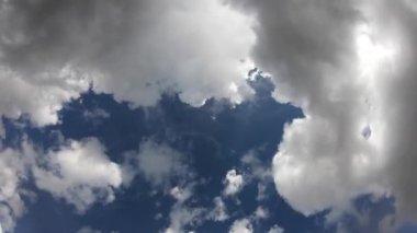 4 bin. Bulutların mavi gökyüzündeki zamanı. Güneş ışınları bulutların arasından geçer. Bazı bulutlar karanlık.