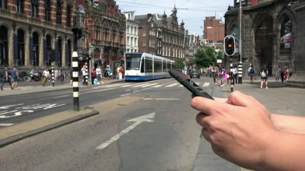 Амстердам Нідерланди Липня 2018 Людина Користується Смартфоном Очікуючи Перейти Центральну — стокове відео