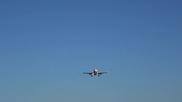 商业客机在蓝天中失去高度 准备在机场着陆 天空中没有云彩 — 图库视频影像