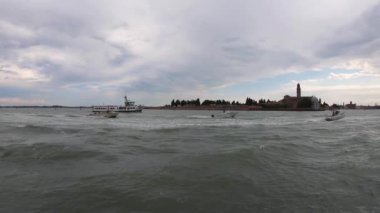 4 bin. İtalya, Venedik 'teki San Michele adasının sularından görüntüler. Venedik Gölünün manzarası, Venedik 'in tarihi mezarlığı. Tekneler yelken açıyor.