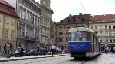 Prag, Çek Cumhuriyeti-13 Temmuz 2018: 4K. Eski tramvay kapılarını kapatır ve Prag 'ın merkez bölgesinde devam eder. Birçok turist tramvayı bekliyor. Çevredeki tarihi binalar
